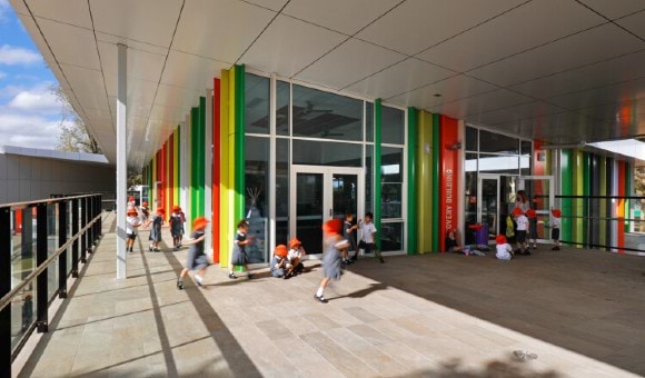 Primary school children playing outside the entrance of a school